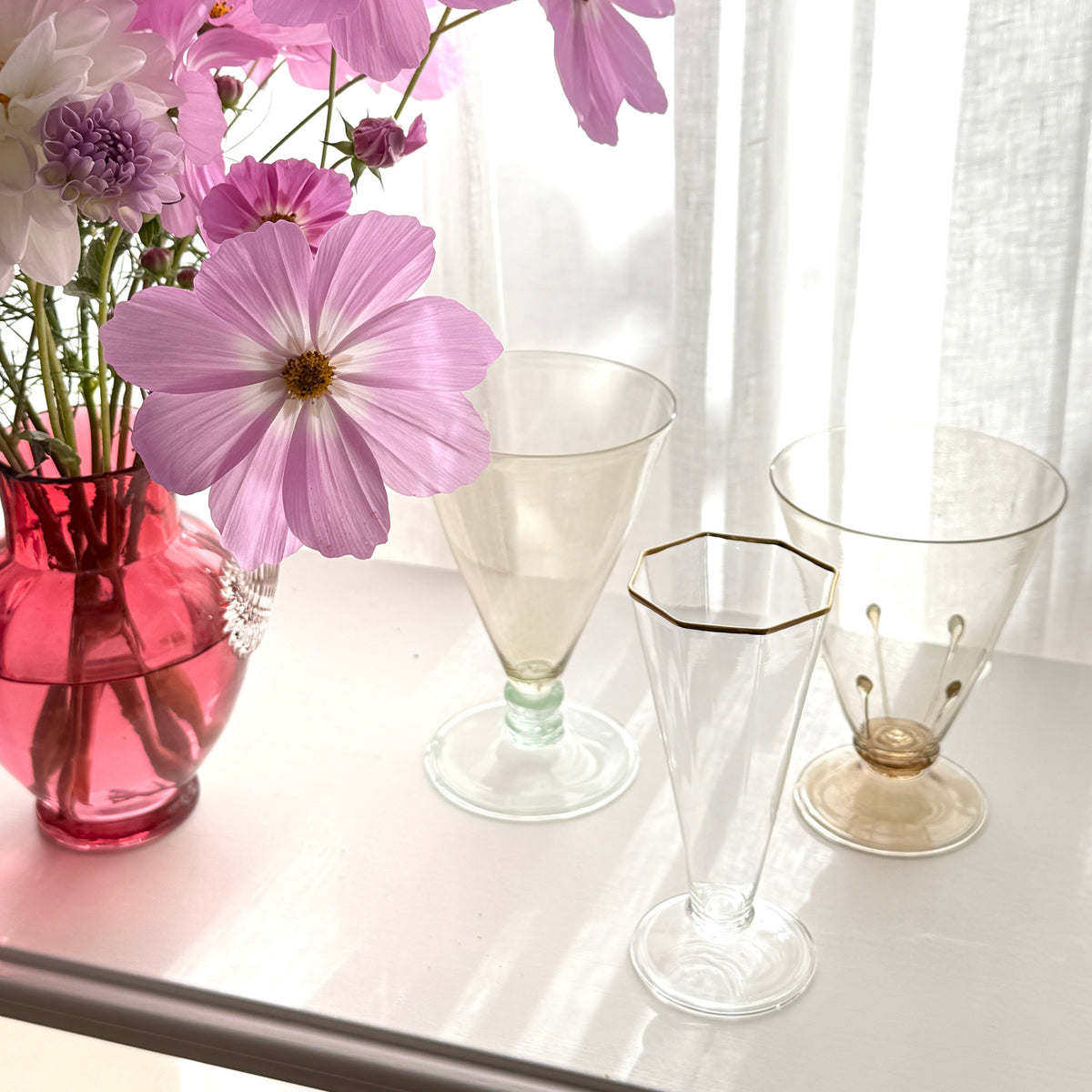 Hanblown goblets and champagne flute with vase with pink flowers