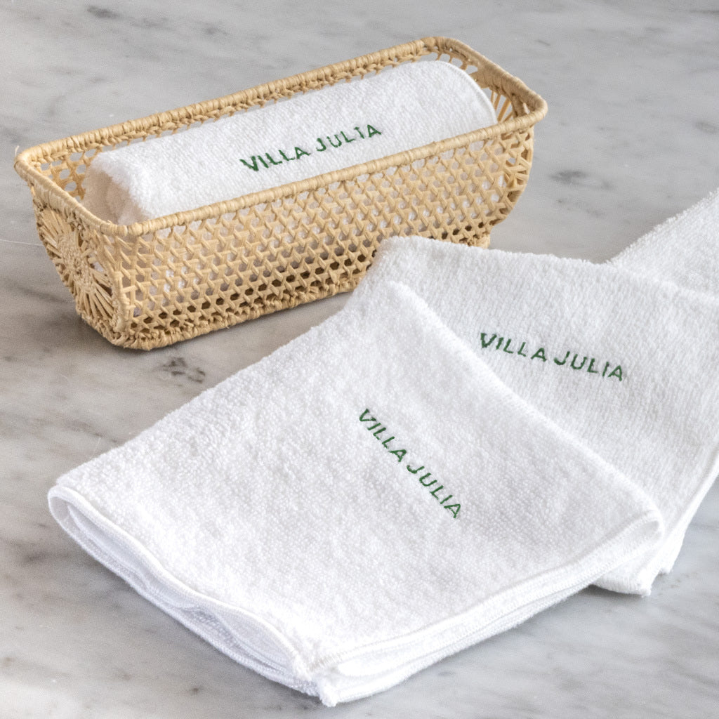 Oshibori white terry towels with Villa Julia Green embroidered monogram with a small straw basket.